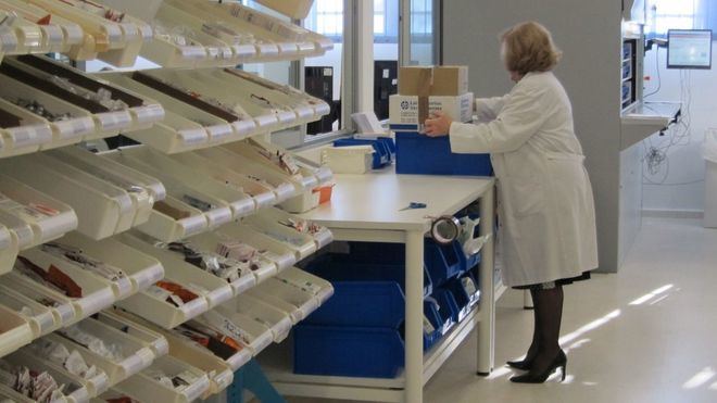 Una mujer trabajando en una farmacia. 